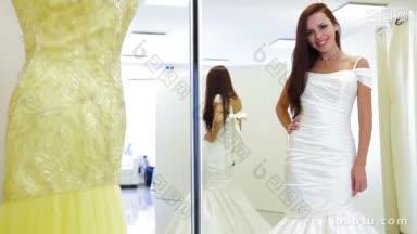 年轻迷人的新娘在婚纱店试婚纱摆姿势，看着镜头